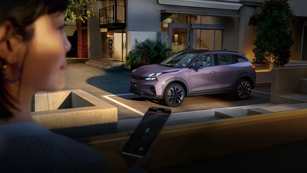 Lynk & Co 06 Relive أمام مبنى مع عرض التطبيق في المقدمة